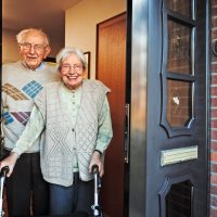 Happy,Elderly,Couple,Opening,The,Front,Door